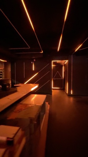 Amber linear lights tracing Anthem Orlando’s ceiling and angular doorway