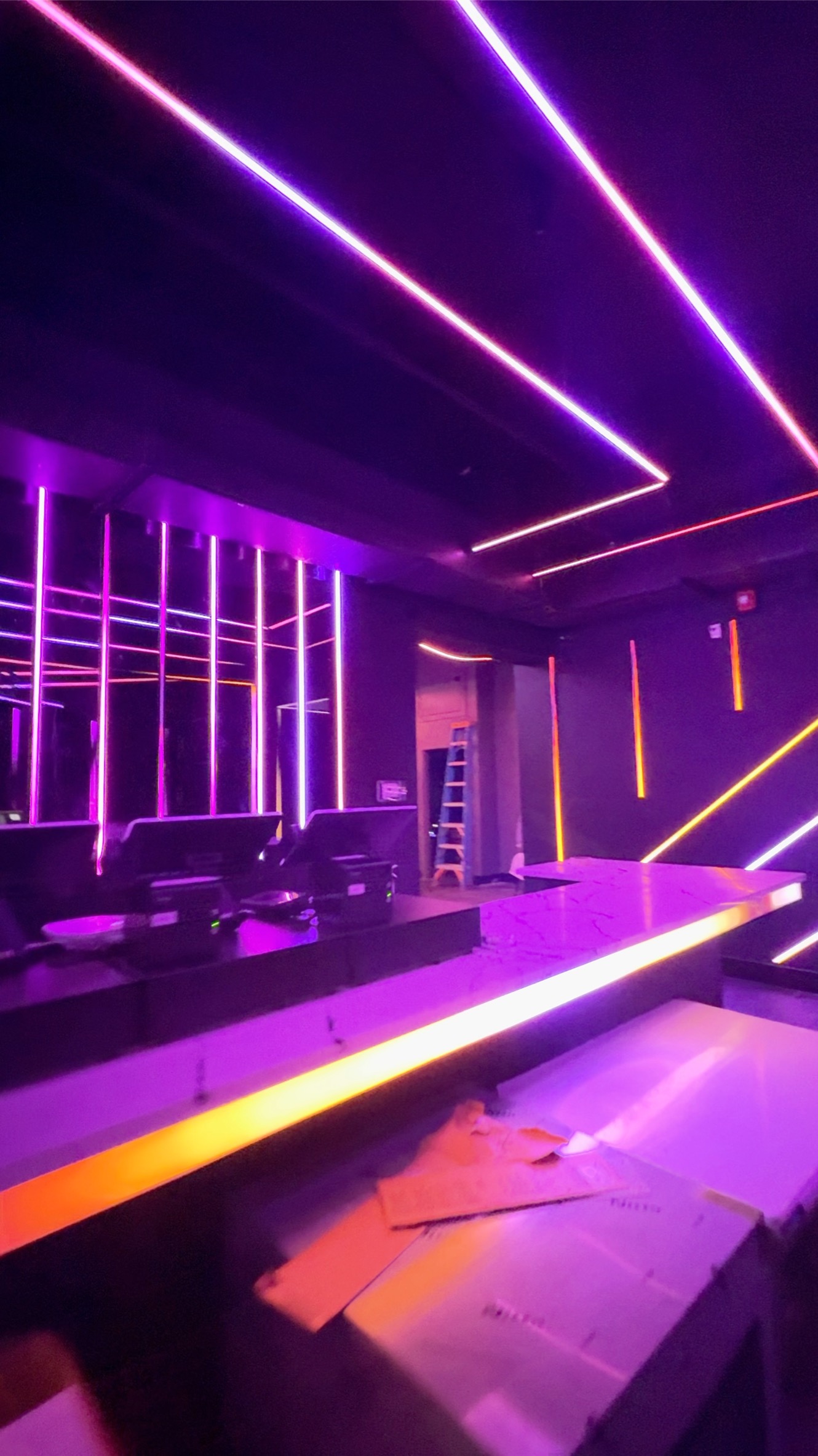 Violet and amber light tracing the ceiling, mirrored back bar and counter at Anthem Orlando