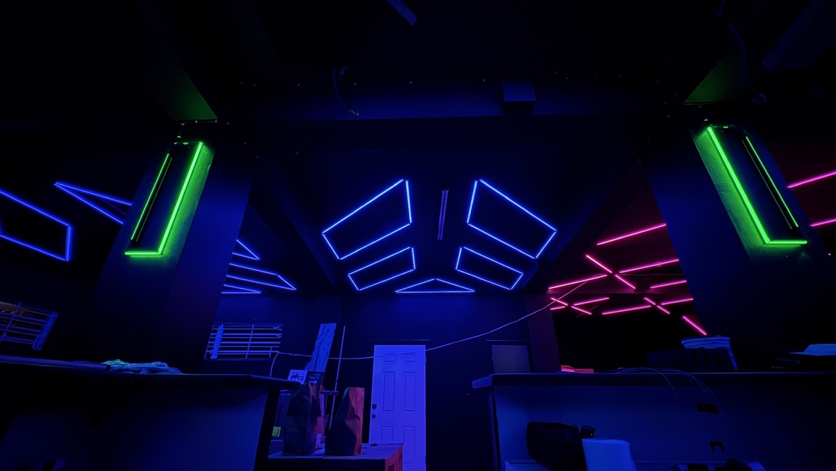 Green illuminated columns framing blue and pink ceiling fixtures at Havoc