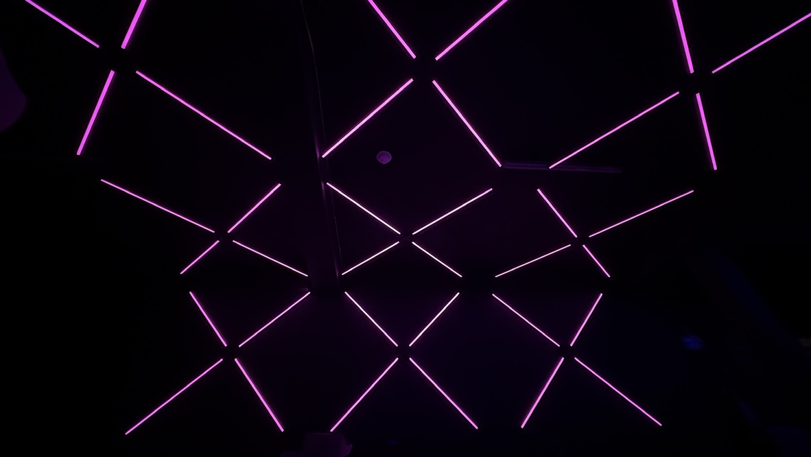 Intersecting pink light patterns on the walls and ceiling at Havoc