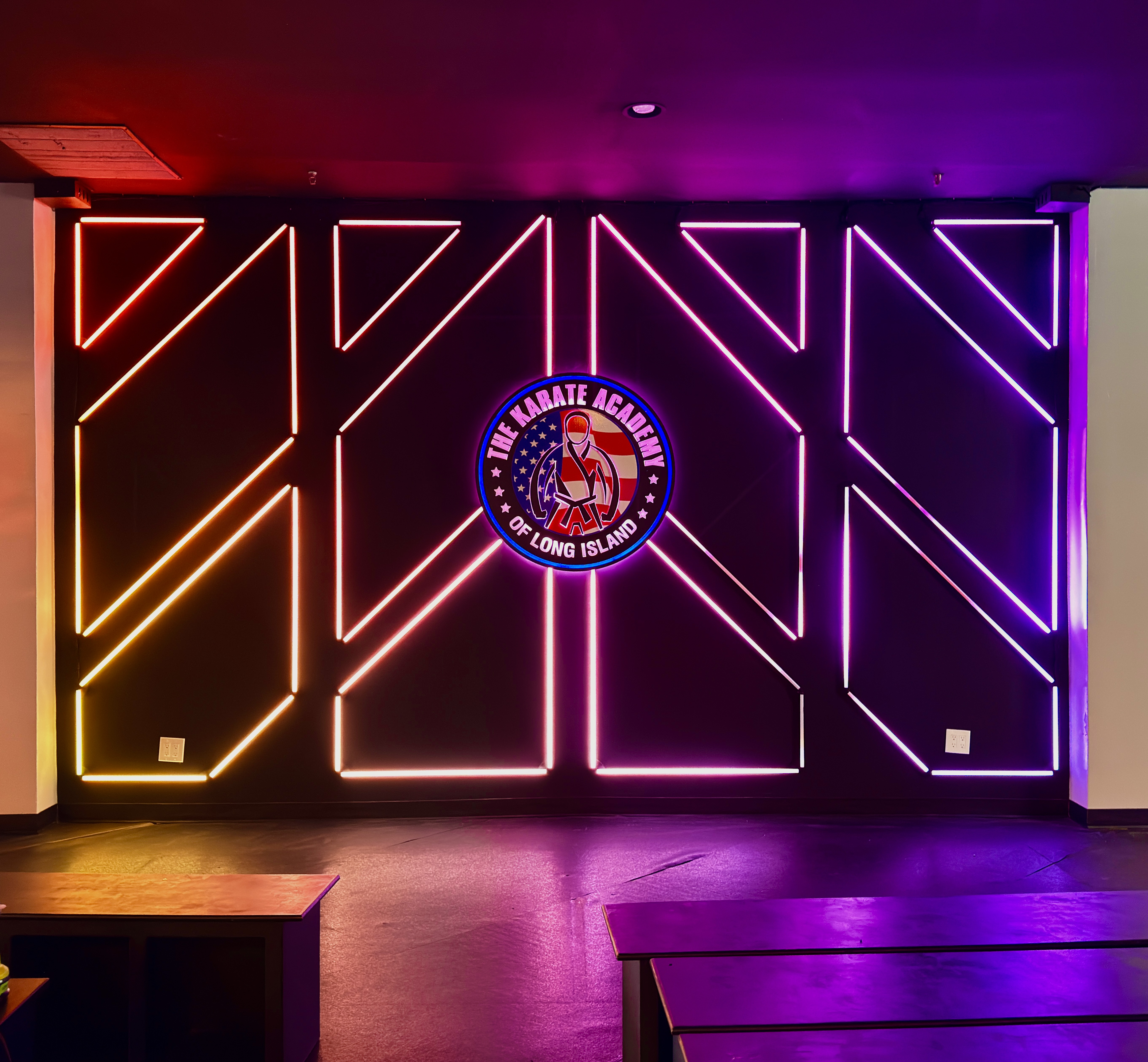 Multicolor LED lines framing The Karate Academy of Long Island crest