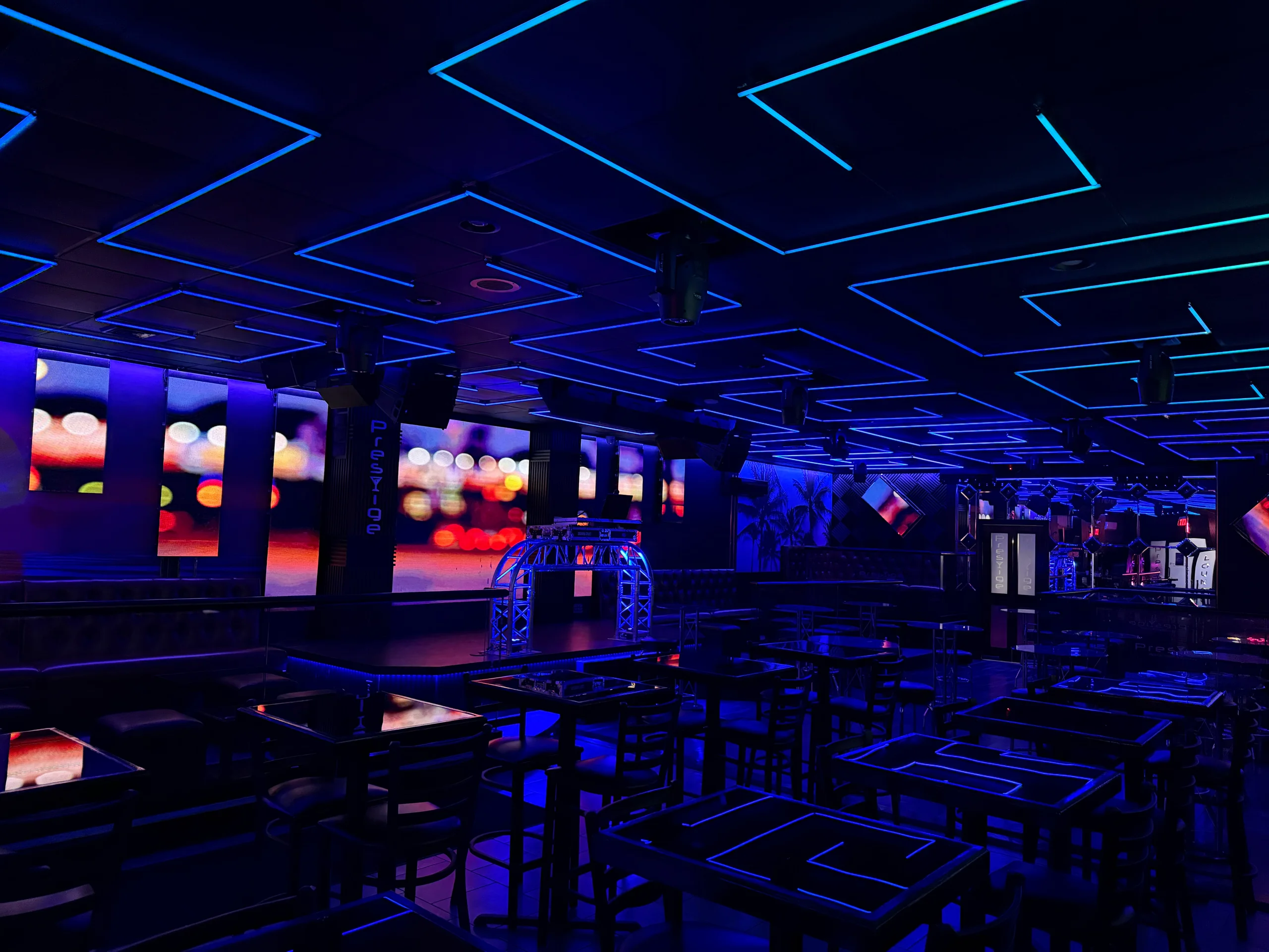 Angular blue and cyan LED ceiling fixtures above the stage and tables at Prestige in Hazleton, PA
