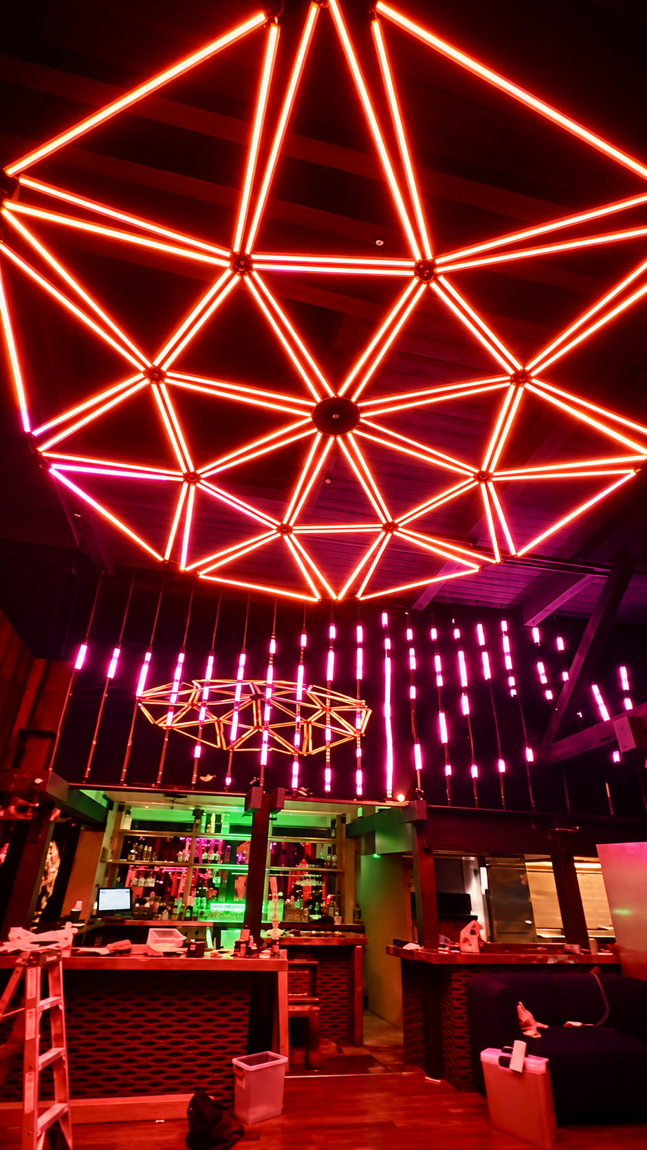 Glowing red and pink geometric ceiling lights at V’s Paradise in Sacramento, California